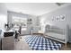 Bedroom featuring a crib, work station, rocking chair, and a soft blue and white rug at 13228 E Asbury Dr, Aurora, CO 80014