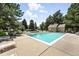 Community pool surrounded by lush landscaping, lounge chairs, and cabana-style building at 13228 E Asbury Dr, Aurora, CO 80014