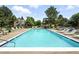 Community pool with lounge chairs, trees, and well maintained landscaping with buildings in the background at 13228 E Asbury Dr, Aurora, CO 80014
