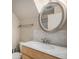 Cozy bathroom featuring wood vanity, stainless steel hardware and round mirror at 3593 S Kittredge St # E, Aurora, CO 80013