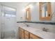 Bathroom with double sink vanity, wood cabinets, large mirror and tile backsplash at 3593 S Kittredge St # E, Aurora, CO 80013