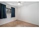 A bedroom with a ceiling fan, window with blue curtains and carpeted floors at 3593 S Kittredge St # E, Aurora, CO 80013