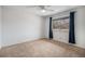 Spacious bedroom with a ceiling fan, window with blue curtains and carpeted floors at 3593 S Kittredge St # E, Aurora, CO 80013