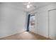 A bedroom with a ceiling fan, window with blue curtains, closet and carpeted floors at 3593 S Kittredge St # E, Aurora, CO 80013