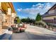 Backyard patio with outdoor seating area and fire pit surrounded by trees and bushes at 10480 Skyreach Rd, Highlands Ranch, CO 80126