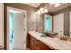Bright bathroom with double sinks and a view into the tiled shower and toilet area at 10480 Skyreach Rd, Highlands Ranch, CO 80126