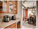 Butler's pantry featuring granite countertops, wood cabinets, and direct access to the dining room at 10480 Skyreach Rd, Highlands Ranch, CO 80126