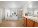 Bright bathroom with a soaking tub, glass-enclosed shower, and wooden vanity at 16706 E Black Horn Dr, Parker, CO 80134