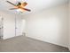 A carpeted bedroom with a ceiling fan and two doors at 16706 E Black Horn Dr, Parker, CO 80134