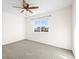 A carpeted bedroom with a ceiling fan and a window that offers natural light and neighborhood views at 16706 E Black Horn Dr, Parker, CO 80134