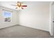 A carpeted bedroom with a ceiling fan and a window that offers natural light and neighborhood views at 16706 E Black Horn Dr, Parker, CO 80134