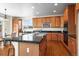 Well-equipped kitchen featuring wood cabinetry, a center island, and modern appliances at 16706 E Black Horn Dr, Parker, CO 80134