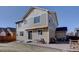 Picture of the tan two-story house exterior with a brick patio and grassy backyard under a clear blue sky at 3164 S Kirk Way, Aurora, CO 80013