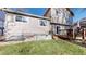 Backyard featuring a wood deck, green grass, and beige vinyl siding in this single Gathering home at 17588 E Dickenson Pl, Aurora, CO 80013