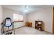 Bright bedroom featuring a window, a ceiling fan, wooden desk, and shelving unit at 17588 E Dickenson Pl, Aurora, CO 80013
