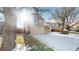 Two-story home with beige siding, a two-car garage, and a snow-covered yard with partial sunlight at 17588 E Dickenson Pl, Aurora, CO 80013