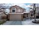 Two-story home with a covered porch, attached garage, landscaped front yard covered in winter snow at 17588 E Dickenson Pl, Aurora, CO 80013