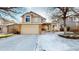 Charming two-story home featuring an attached garage, covered front porch and well-kept landscaping in winter at 17588 E Dickenson Pl, Aurora, CO 80013