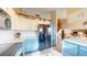 Spacious kitchen with a center island, black appliances, and white and blue cabinets at 17588 E Dickenson Pl, Aurora, CO 80013