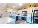 Updated kitchen with blue lower cabinets, white upper cabinets, and stainless steel appliances at 17588 E Dickenson Pl, Aurora, CO 80013