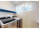 Well-equipped laundry room with modern washer and dryer and a convenient shelf above at 17588 E Dickenson Pl, Aurora, CO 80013
