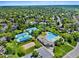 Community aerial view showcasing tennis courts, a pool, and a clubhouse surrounded by lush greenery and residences at 4626 E Links Dr, Centennial, CO 80122