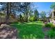 A lush green backyard features a well-maintained lawn and mature trees perfect for outdoor enjoyment at 4626 E Links Dr, Centennial, CO 80122