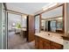 Well lit bath featuring a double sink vanity and mirrored closet doors, leading into the bedroom at 4626 E Links Dr, Centennial, CO 80122