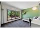 Sunny bedroom with large windows, green accent wall, and modern lighting creating a vibrant atmosphere at 4626 E Links Dr, Centennial, CO 80122