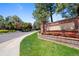 Community entrance sign features flowers and mature trees, creating an inviting atmosphere for residents at 4626 E Links Dr, Centennial, CO 80122