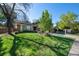 Landscaped front lawn, mature trees, and a glimpse of the home's exterior, creating a welcoming curb appeal at 4626 E Links Dr, Centennial, CO 80122