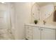 Well-lit bathroom with vanity, large round mirror and combination shower/tub at 10259 Fairgate Way, Highlands Ranch, CO 80126