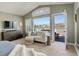 Bedroom with cozy sitting area, balcony access, and large windows with great views at 10259 Fairgate Way, Highlands Ranch, CO 80126