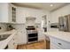 Well-lit kitchen with stainless steel appliances, white cabinets, and modern design at 10259 Fairgate Way, Highlands Ranch, CO 80126