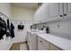 Well-organized laundry room with upper cabinets, counter space, washer, and dryer at 10259 Fairgate Way, Highlands Ranch, CO 80126