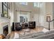 Bright living room featuring a cozy fireplace, large windows, and comfortable seating at 10259 Fairgate Way, Highlands Ranch, CO 80126