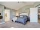 Comfortable carpeted main bedroom with king bed, vaulted ceiling, and ensuite bathroom access at 10259 Fairgate Way, Highlands Ranch, CO 80126