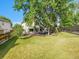 Expansive backyard with a well-manicured lawn, mature trees, and a private deck at 1052 Northampton Ct, Highlands Ranch, CO 80126
