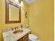 Charming powder room with granite countertop, decorative mirror, and yellow painted walls at 1052 Northampton Ct, Highlands Ranch, CO 80126