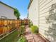 Stone path with blooming roses leading to a gated entrance, lined with lush greenery at 1052 Northampton Ct, Highlands Ranch, CO 80126