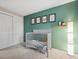 Bedroom featuring a gray crib, accent wall, neutral walls, and a closet at 7049 E Briarwood Cir, Centennial, CO 80112