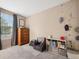 Well-lit bedroom with a dresser, shelving, a gray chair, and a window at 7049 E Briarwood Cir, Centennial, CO 80112