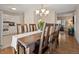 Dining room features wood floors, chandelier lighting, and access to the kitchen at 7049 E Briarwood Cir, Centennial, CO 80112