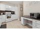 Well-lit kitchen with white cabinets, black countertops, and stainless steel appliances at 7049 E Briarwood Cir, Centennial, CO 80112