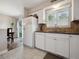 Bright kitchen featuring white cabinetry and ample counter space at 7049 E Briarwood Cir, Centennial, CO 80112