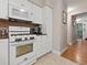 Kitchen with white appliances, tiled backsplash, and plenty of storage at 7049 E Briarwood Cir, Centennial, CO 80112