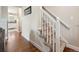 Carpeted staircase with white banister and hardwood flooring at 7049 E Briarwood Cir, Centennial, CO 80112