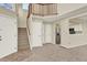 Open-concept entryway with staircase, coat closet, and open view to kitchen featuring stainless steel appliances at 7707 S Monaco Cir, Centennial, CO 80112