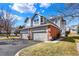 Two-story townhome featuring attached garages, gray siding and brick accents under a bright blue, partly cloudy sky at 7707 S Monaco Cir, Centennial, CO 80112