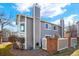 Exterior view of a gray home with tall chimneys and a fenced-in patio at 7707 S Monaco Cir, Centennial, CO 80112